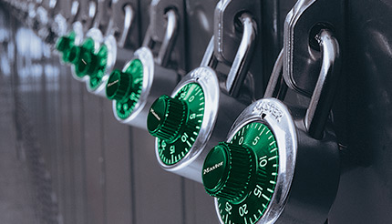 Padlocks with green dials on a row of lockers